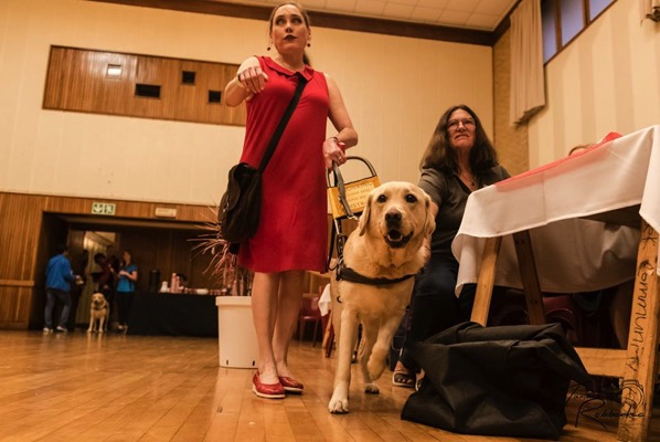 The image shows Lois and Fiji walking through a room of people