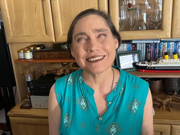 A woman with short dark hair framing her face at cheekbone level. She is smiling at the camera 
